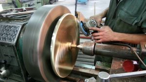 Spinning brass cover for a bar stool base